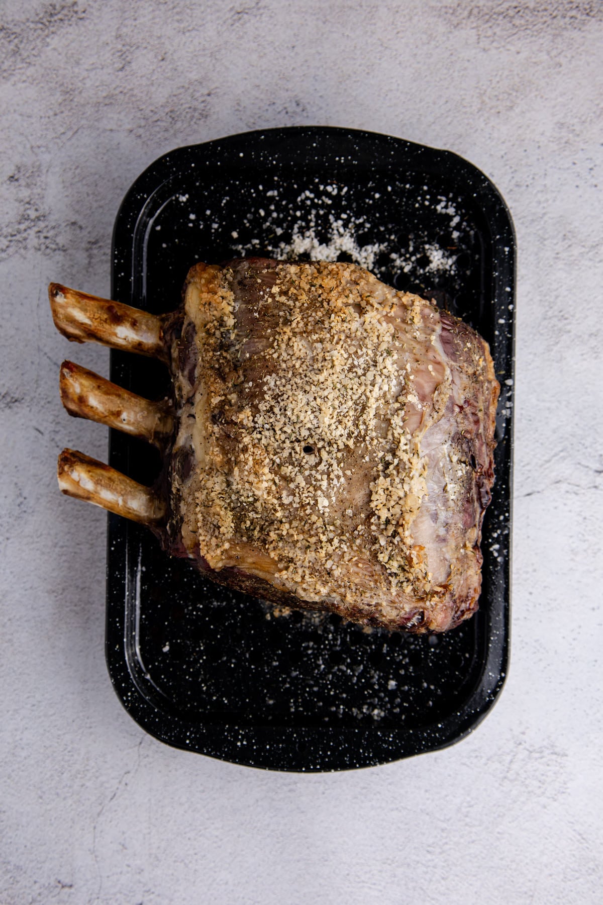 The roast resting after being cooked in a roasting pan.