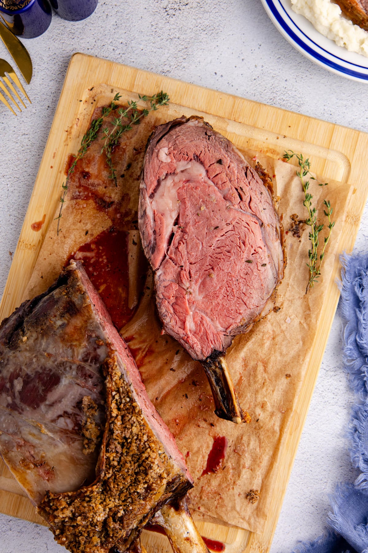 A prime rib sliced off on a cutting board.