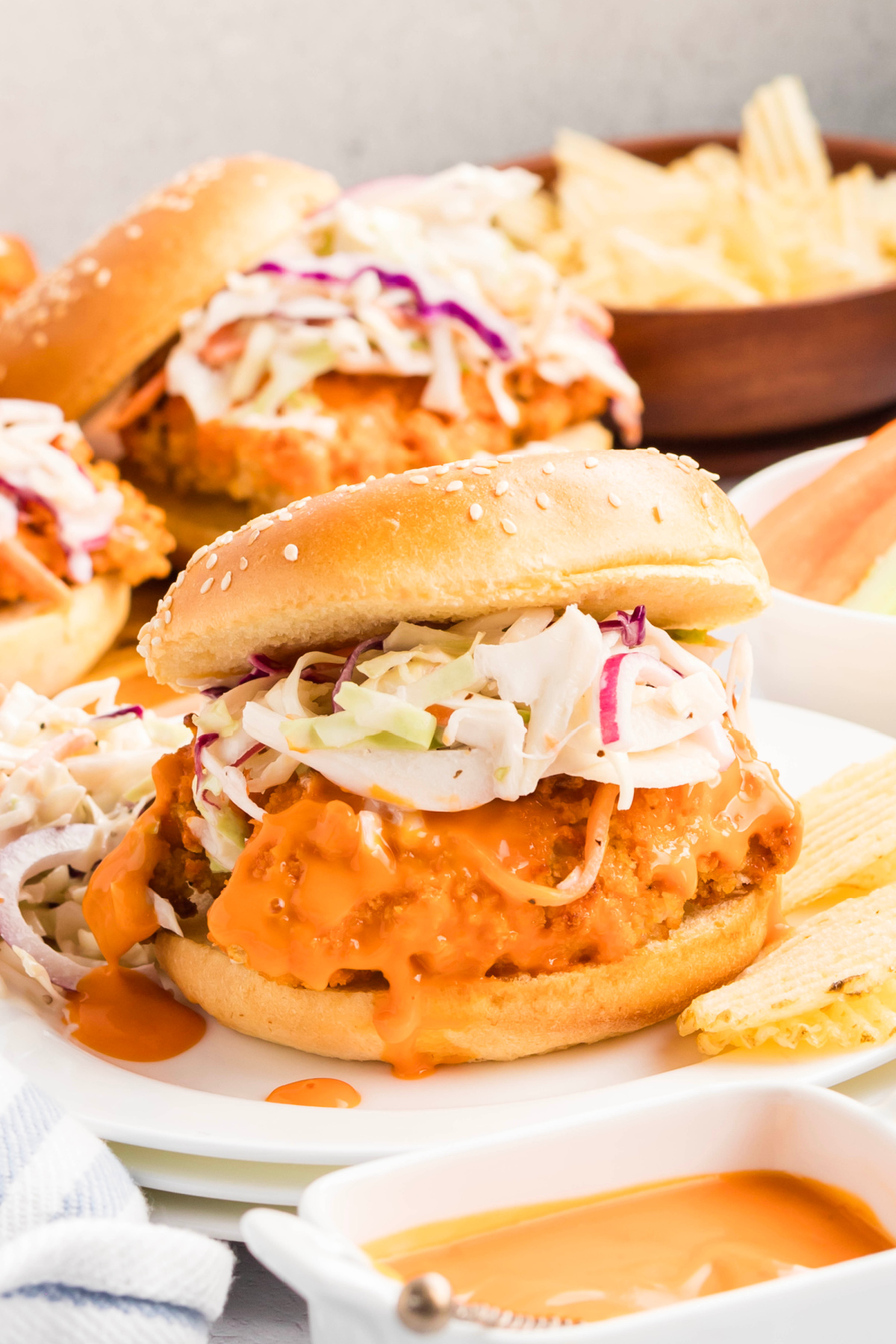 A sandwich with buffalo chicken and coleslaw on a bun.