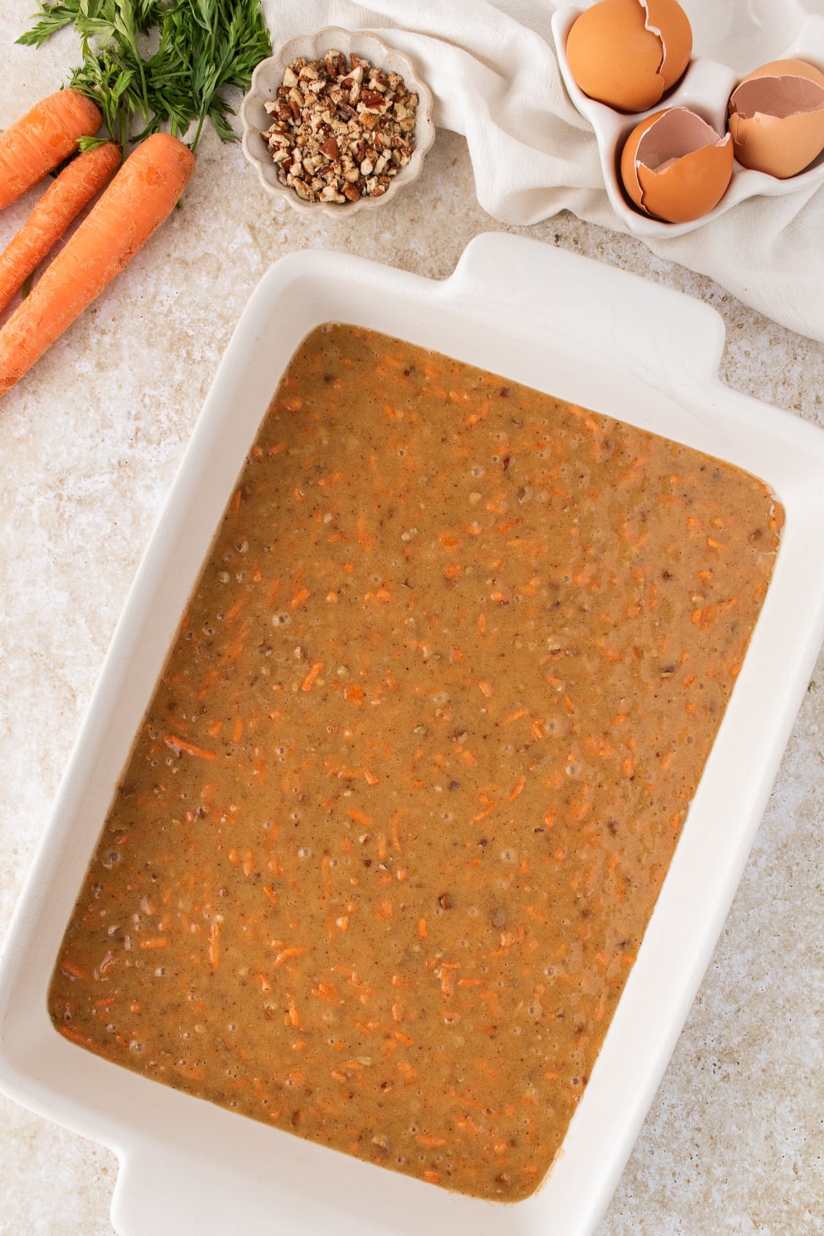 Carrot cake batter combined and poured into a baking sheet.