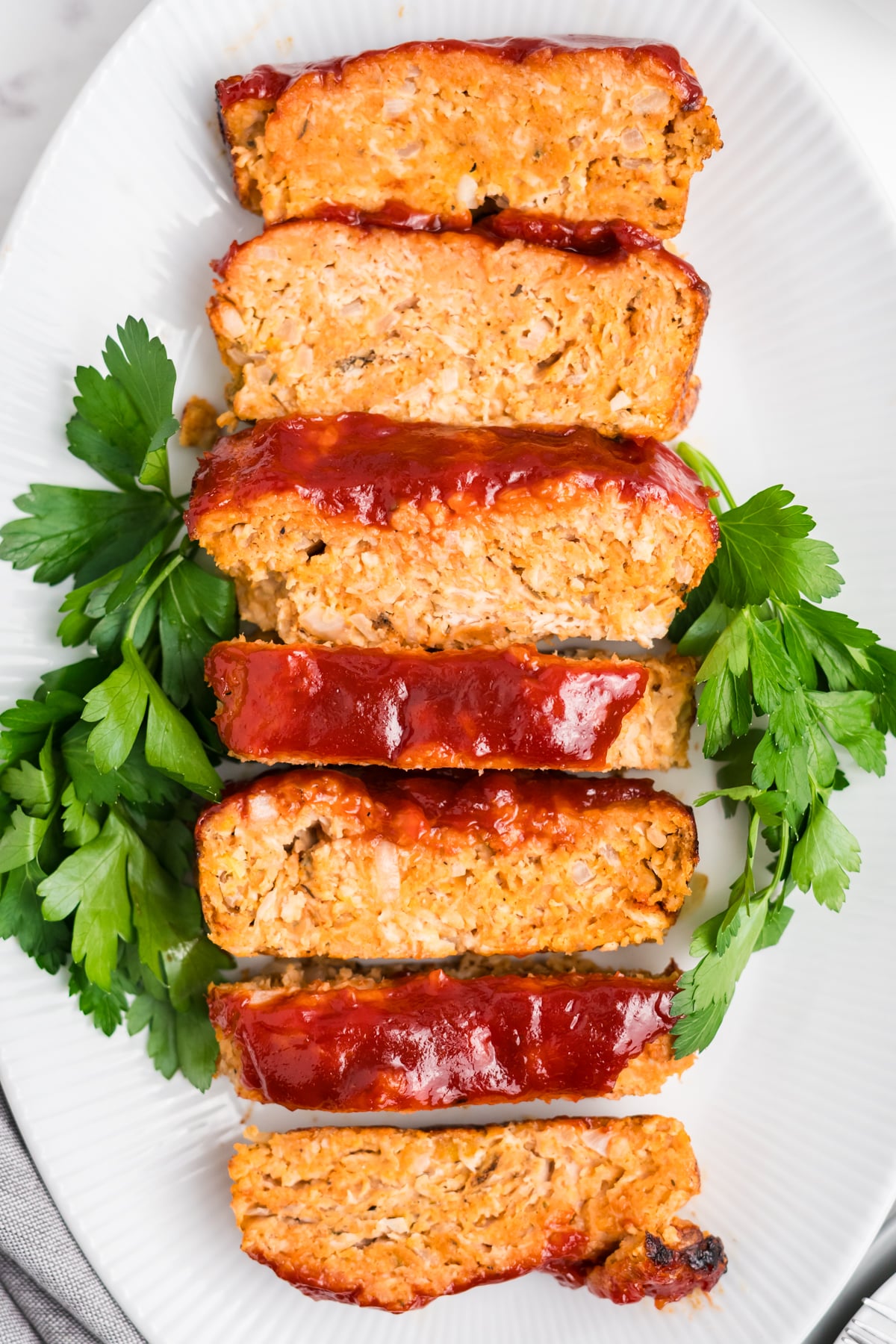 Slices of meatloaf with ground chicken on a plate.