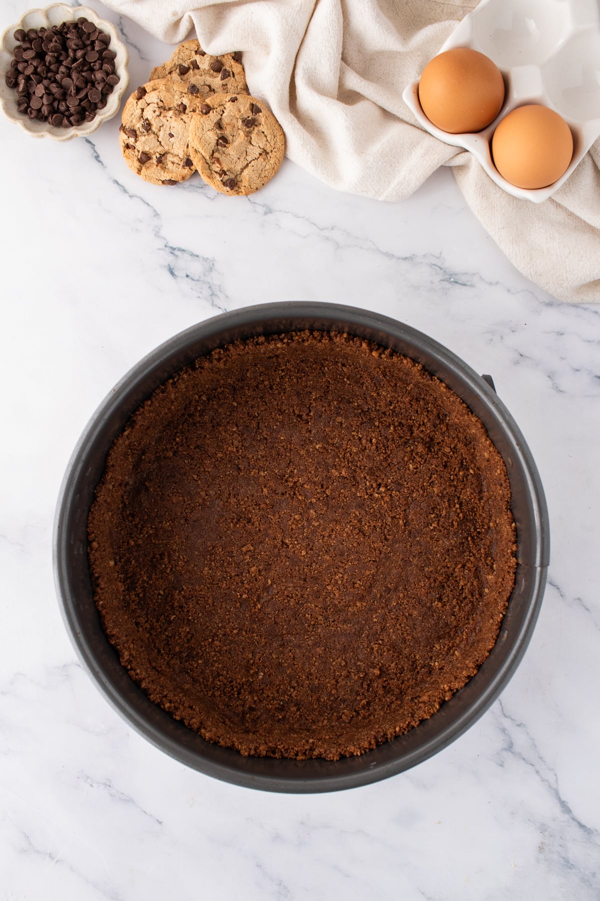 Crumbled cookies pressed into a springform pan.