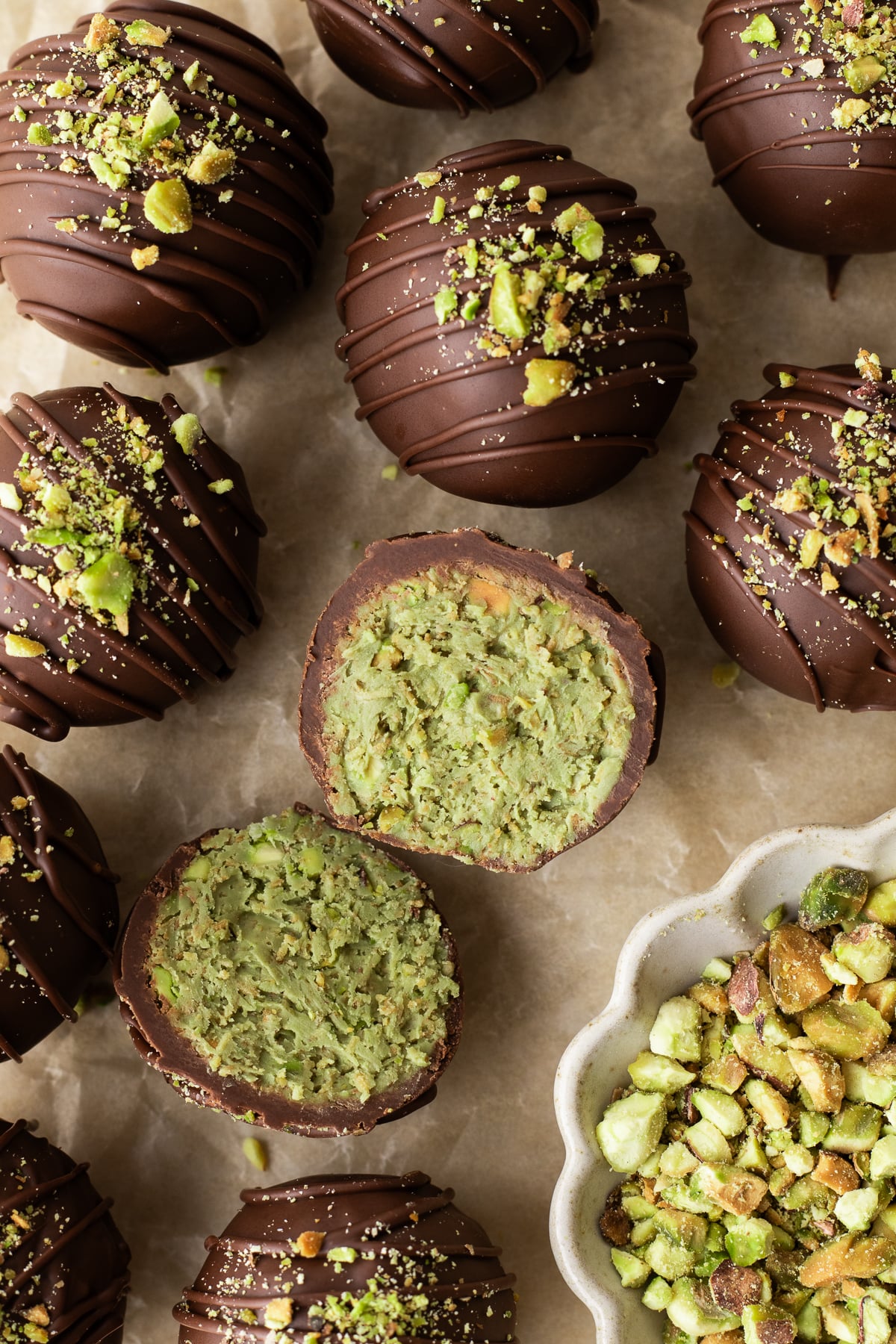 A truffle with pistachio filling split open on a table.
