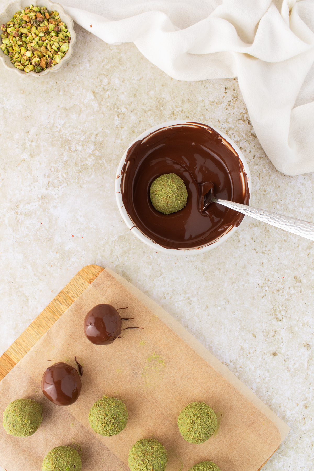 Truffle being dipped into the melted milk chocolate.