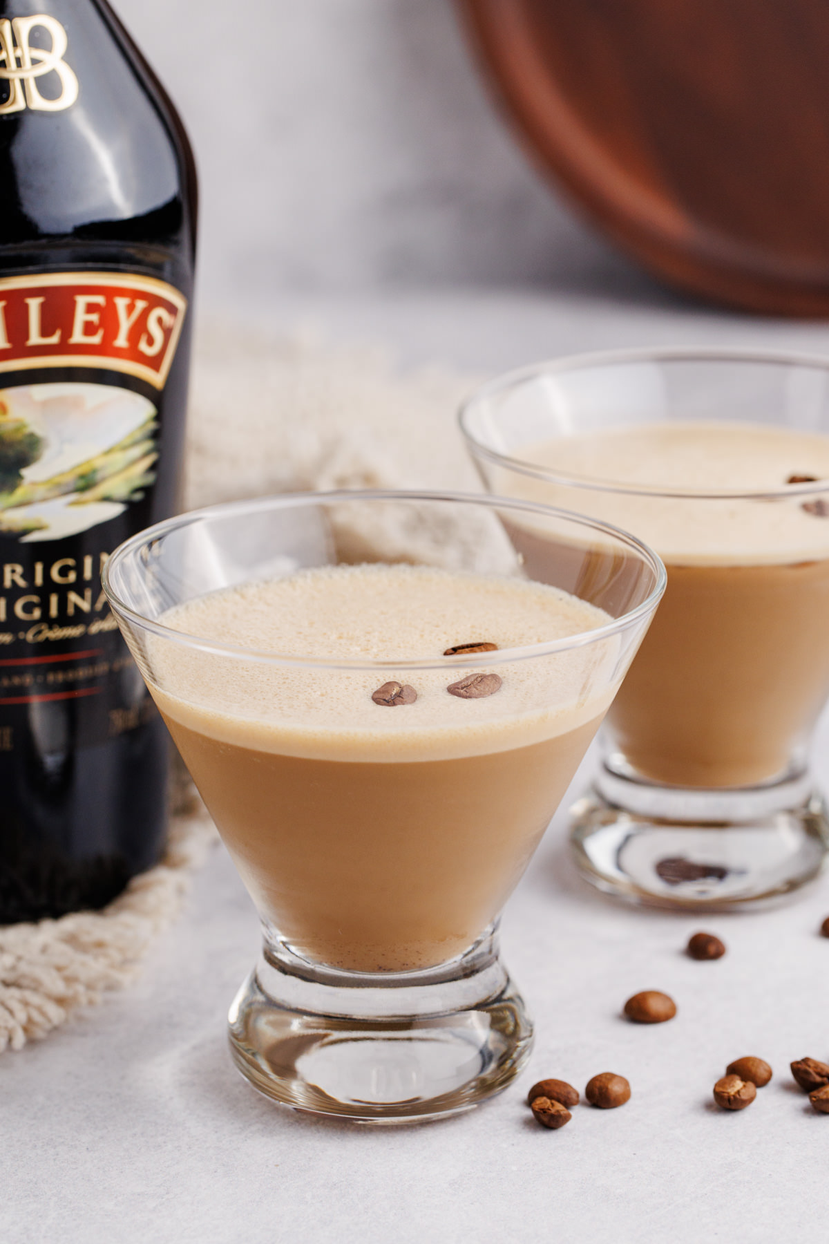 Two glasses filled with a martini with espresso and bailey's on a table.