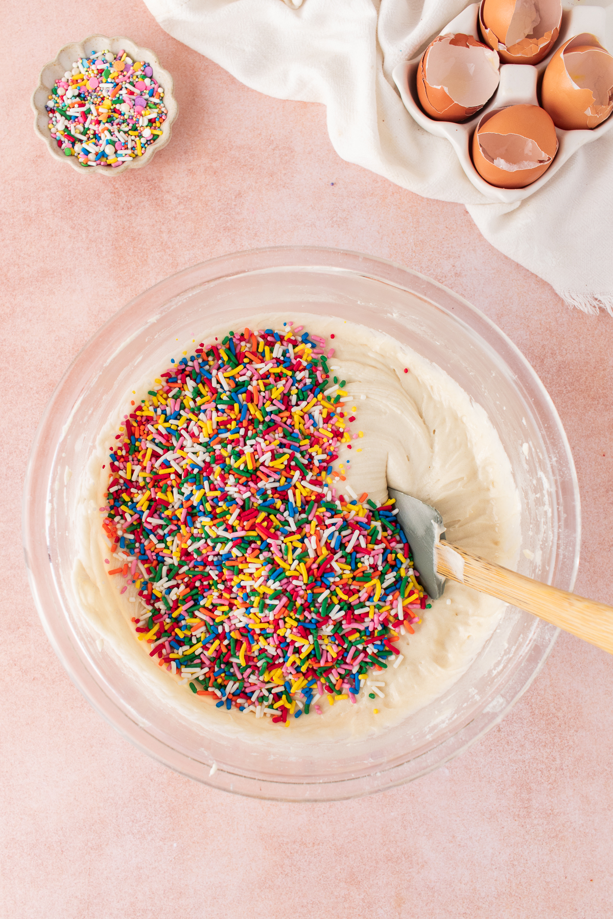 The funfetti bundt cake batter mixed with the sprinkles in a bowl.