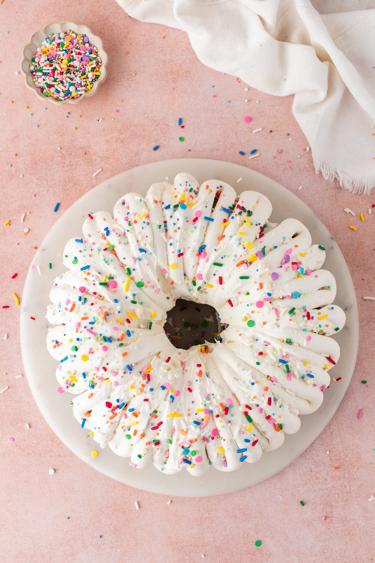 The frosting spread over the cake with sprinkles.