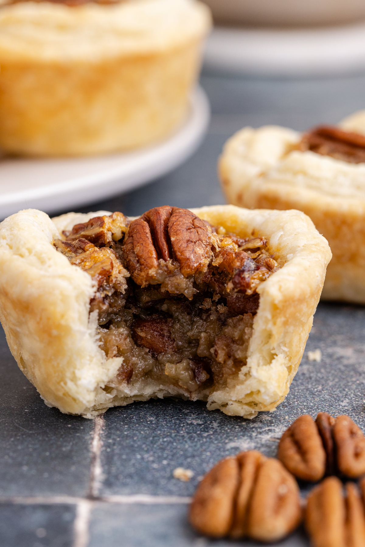 A few mini pies on counter with one in front missing a bite.