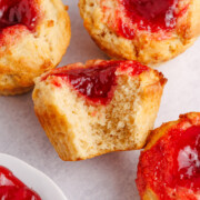 Peanut butter and jelly muffins on a table with a bite taken out of it.
