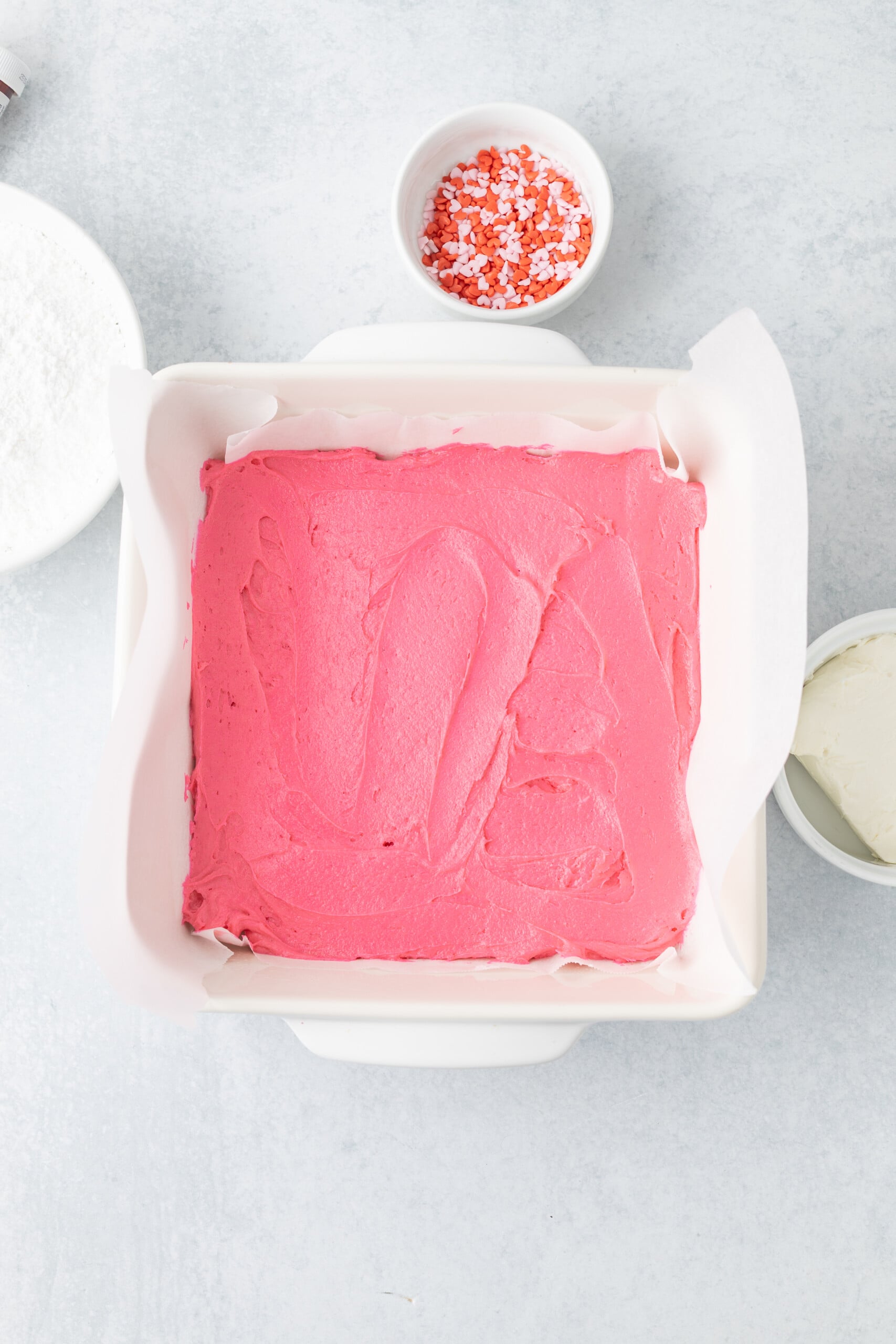 Pink blondie batter poured into a baking dish.