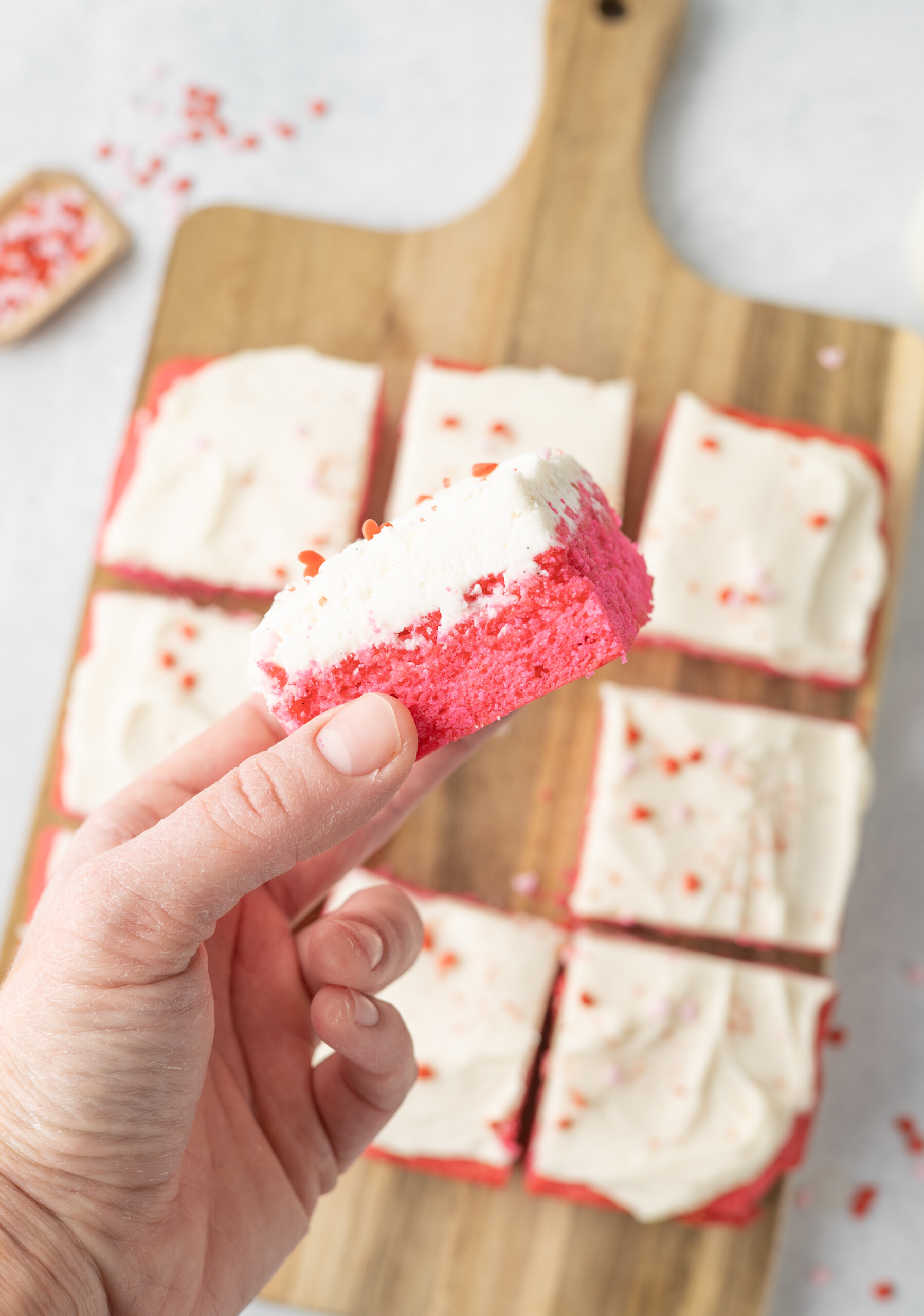 Sliced brownie on a cutting board and one being held up in the air.