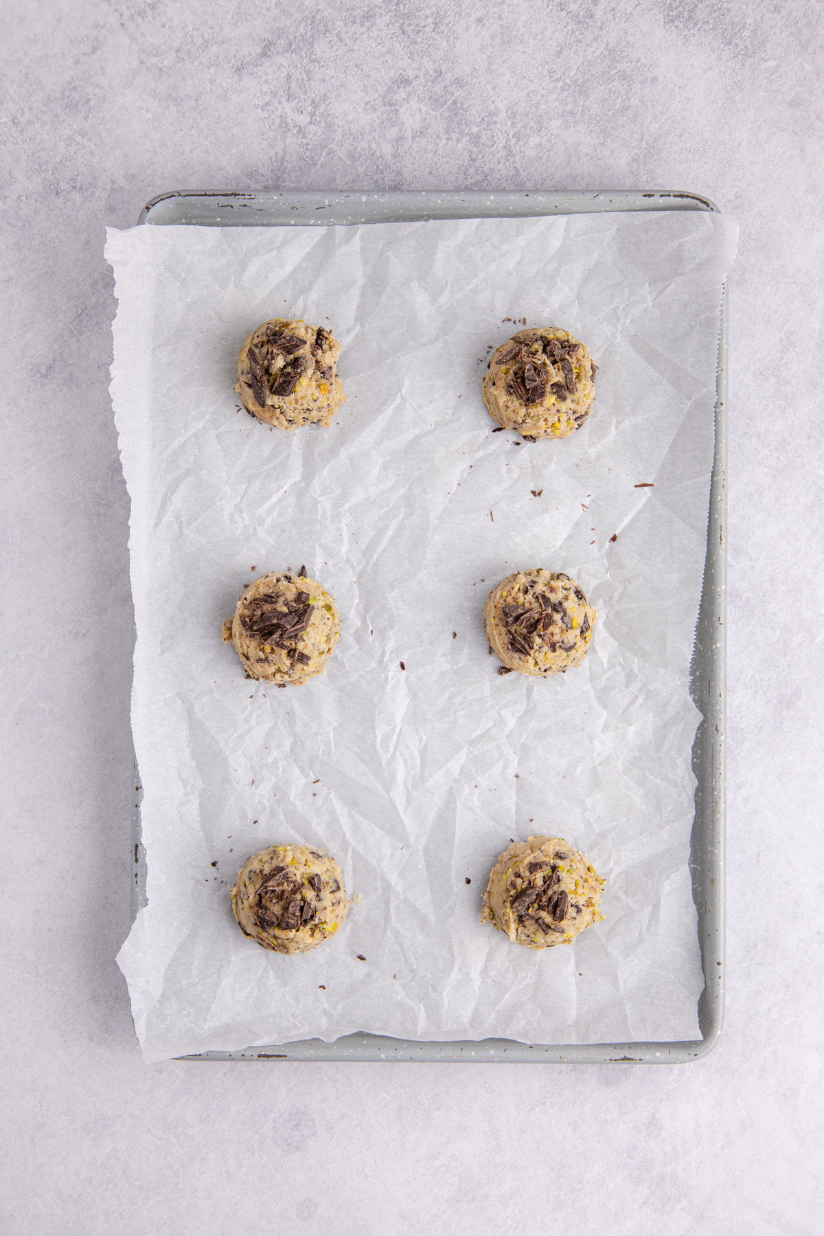 Formed cookie dough balls on a lined sheet pan.
