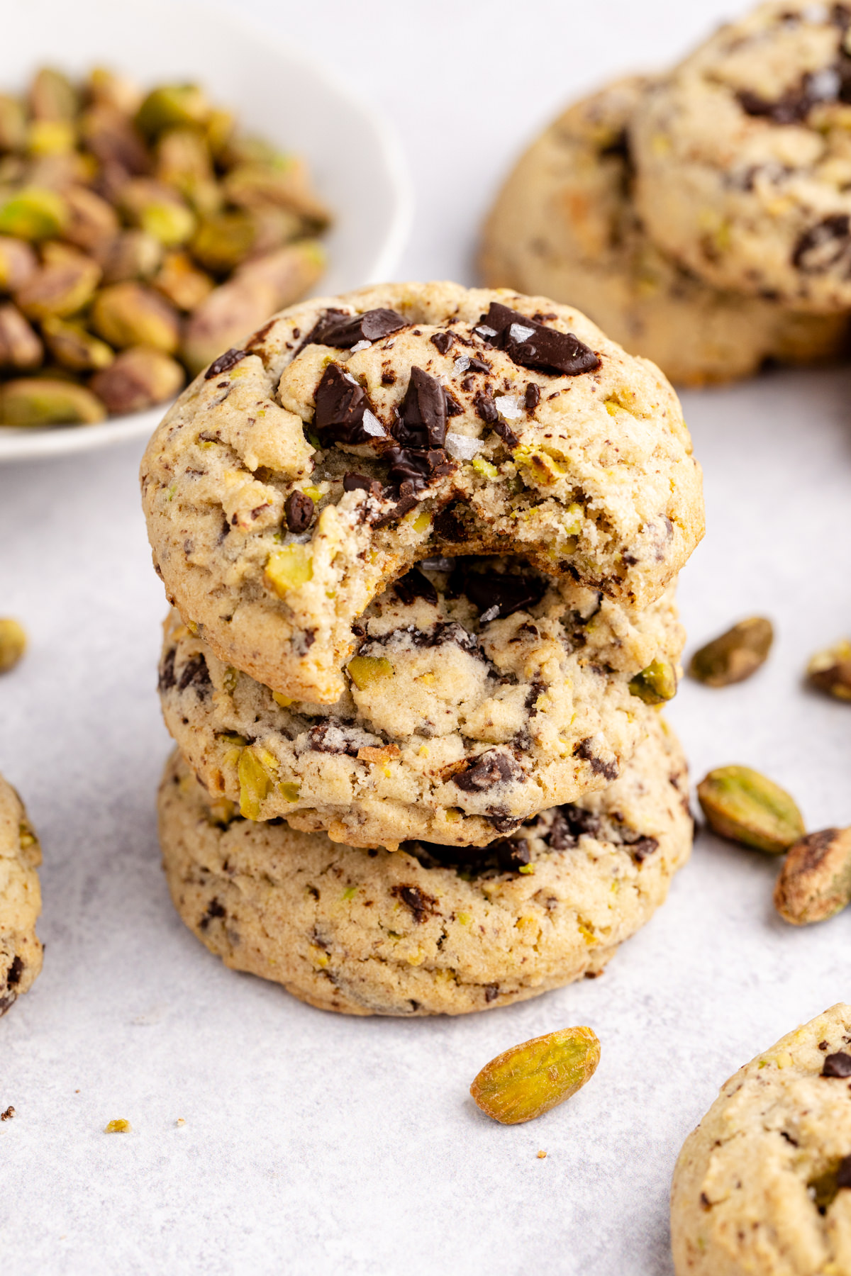 A stack of cookies with a bite taken out of the top cookie.