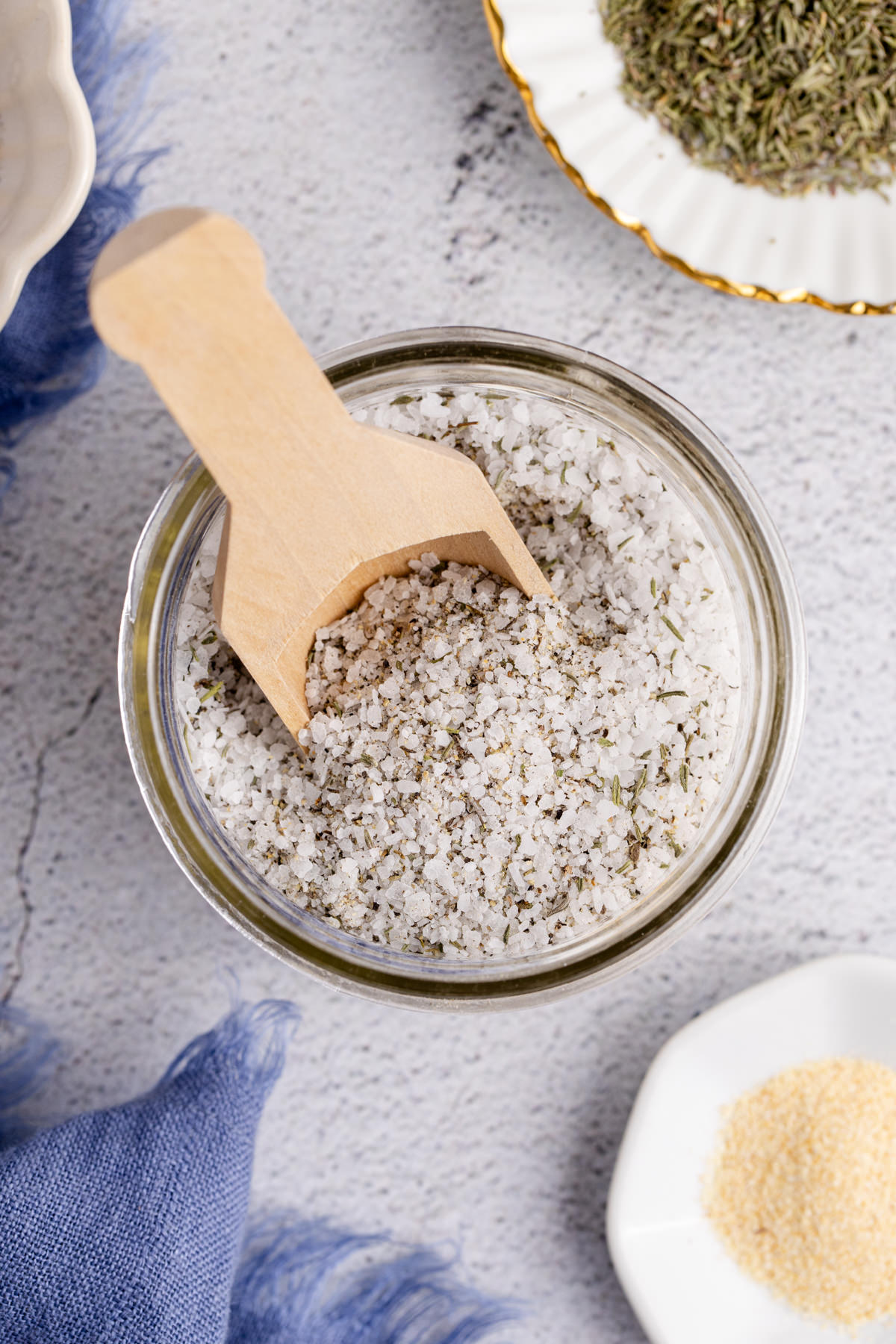 A jar of prime rib rub with a wooden scooper in it.