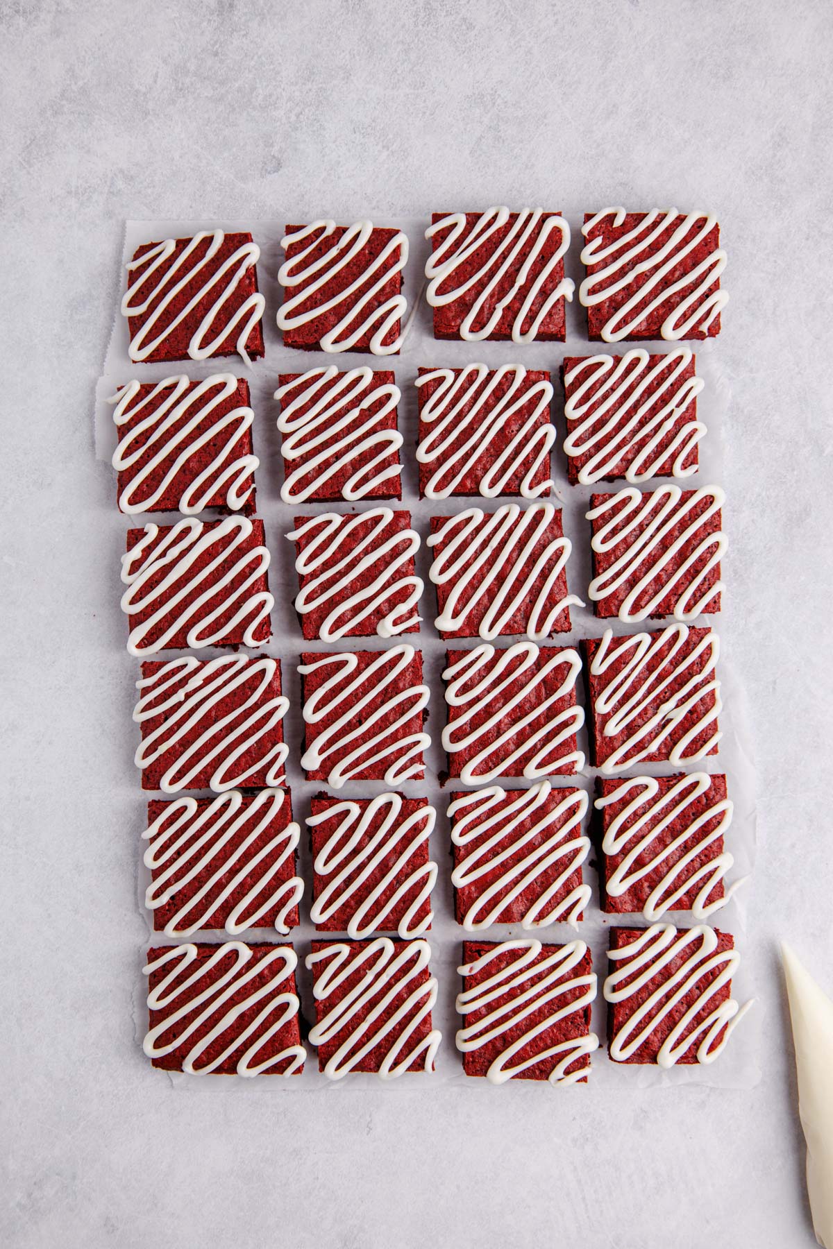 Brownie cut into squares and frosting piped on the top of each.