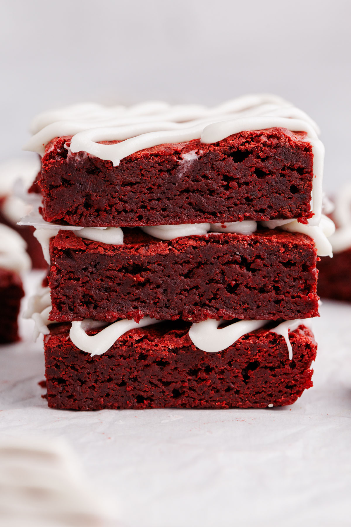 A stack of brownies with icing on top.