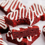 Red velvet brownies stacked on a table.