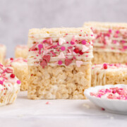 Valentine's rice krispie treats​ stacked on a table.