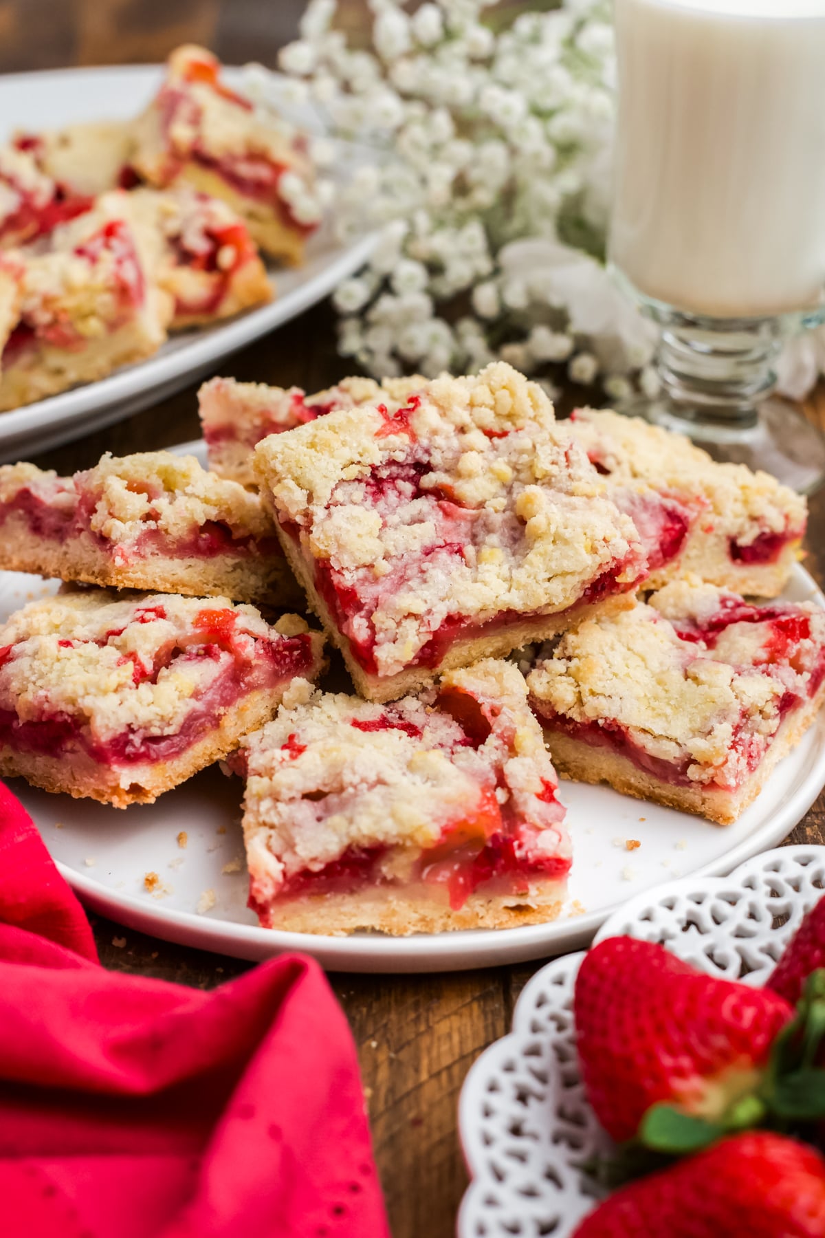 Bars with strawberries stacked on a plate.