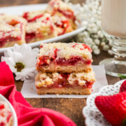 Strawberry bars stacked on parchment paper.