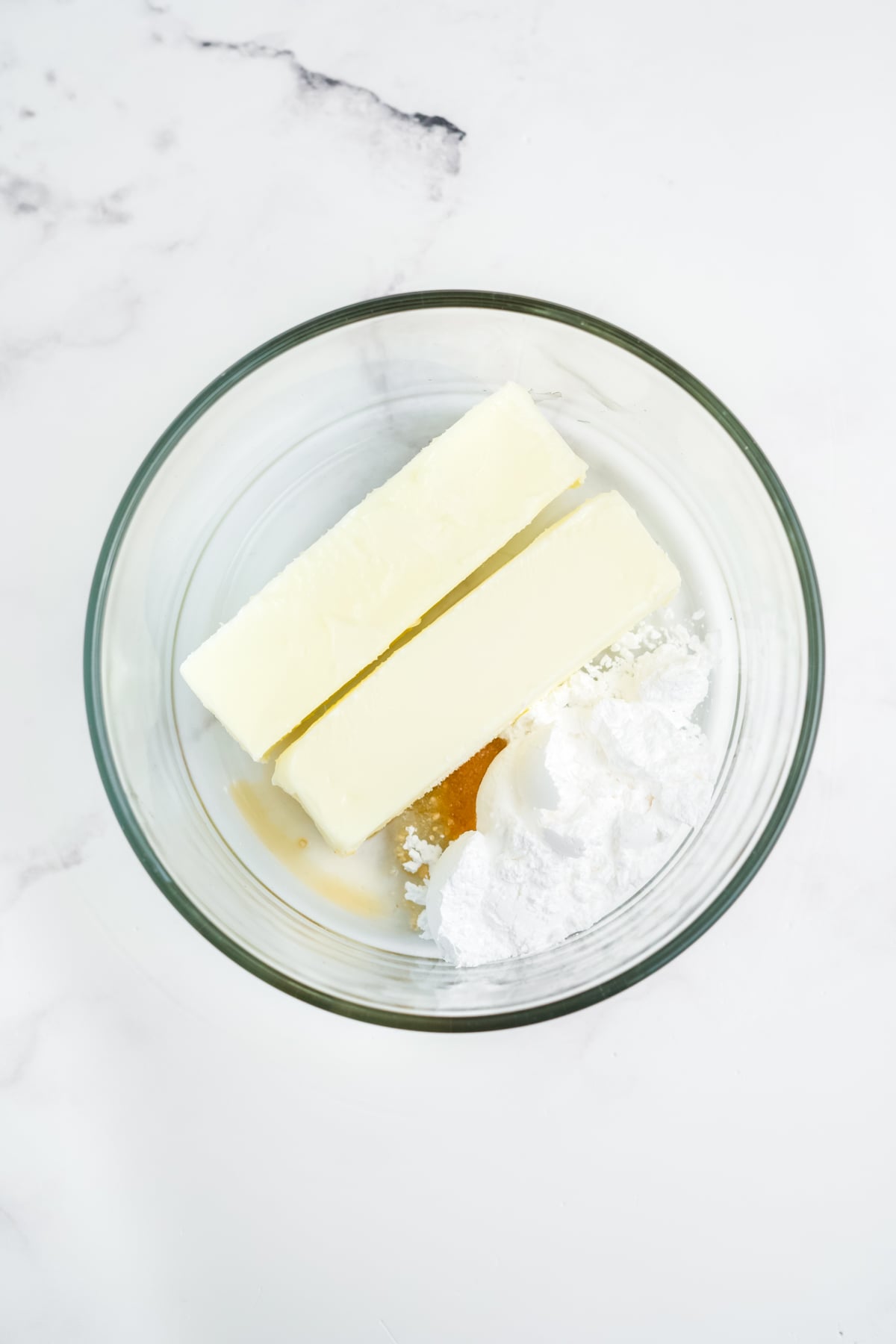 A bowl full of softened butter, powdered sugar, vanilla extract and salt 