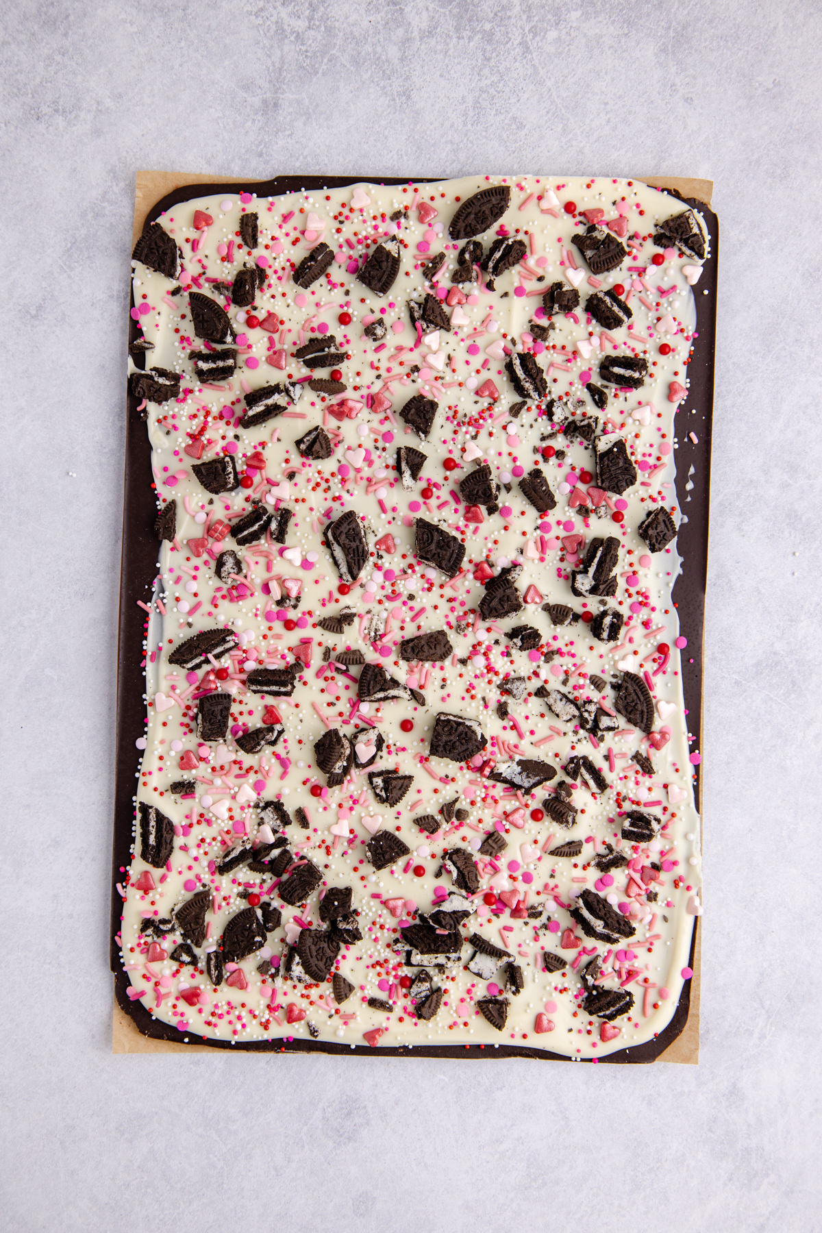 Oreos and sprinkles spread over top of the white chocolate.