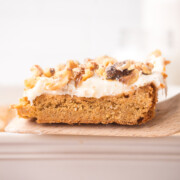 Carrot cake blondie held up in the air with a spatula.