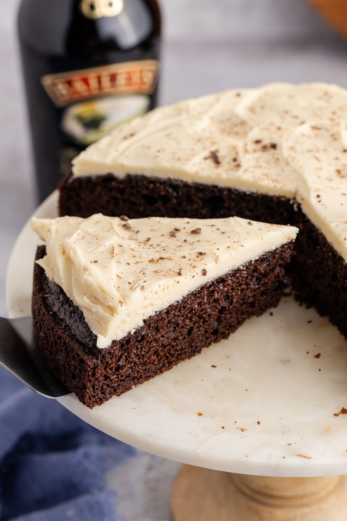A slice of cake with Bailey's frosting on top being lifted up.