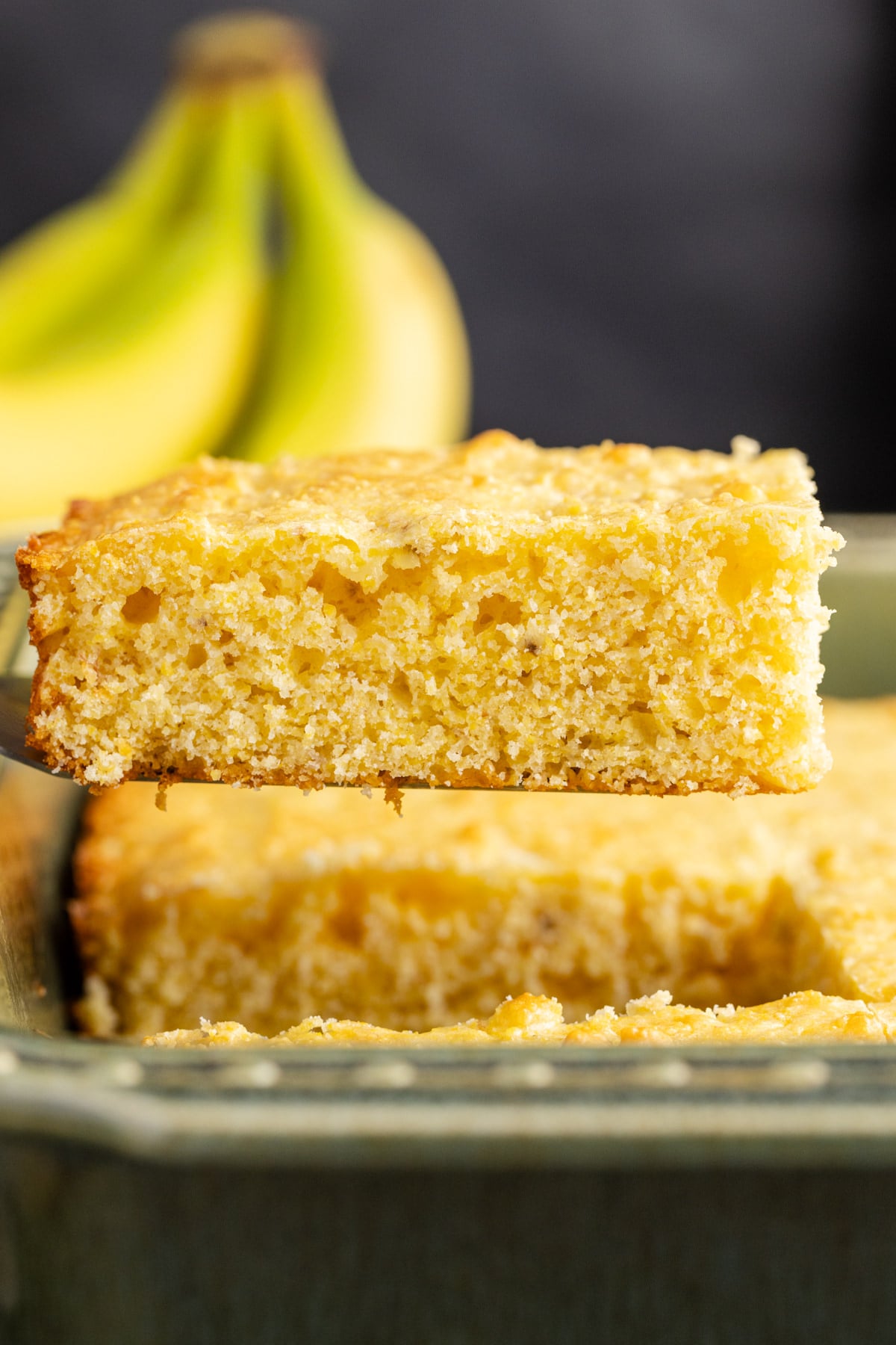 Banana cornbread being held up in the air.