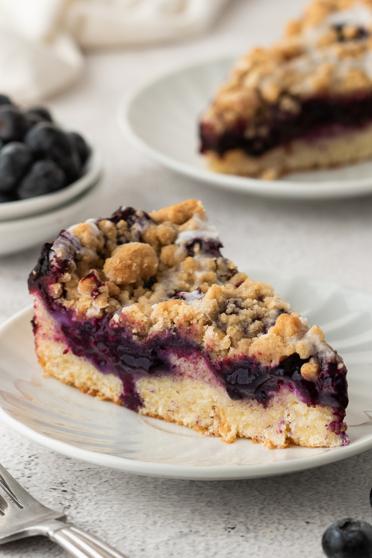 A slice of blueberry crumb cake on a plate.