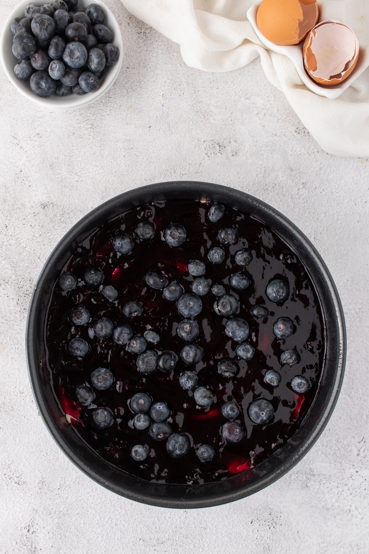 Blueberry jam spread over the top of the cake batter and whole blueberries added on top.