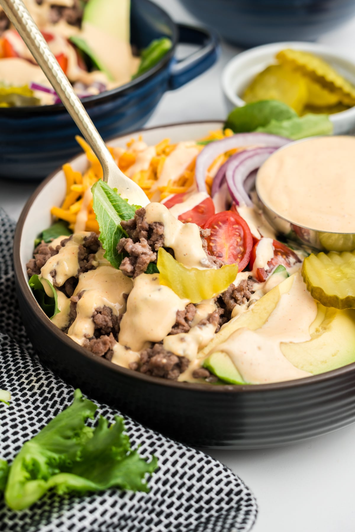 A forkbite being lifted out of the burger bowl.
