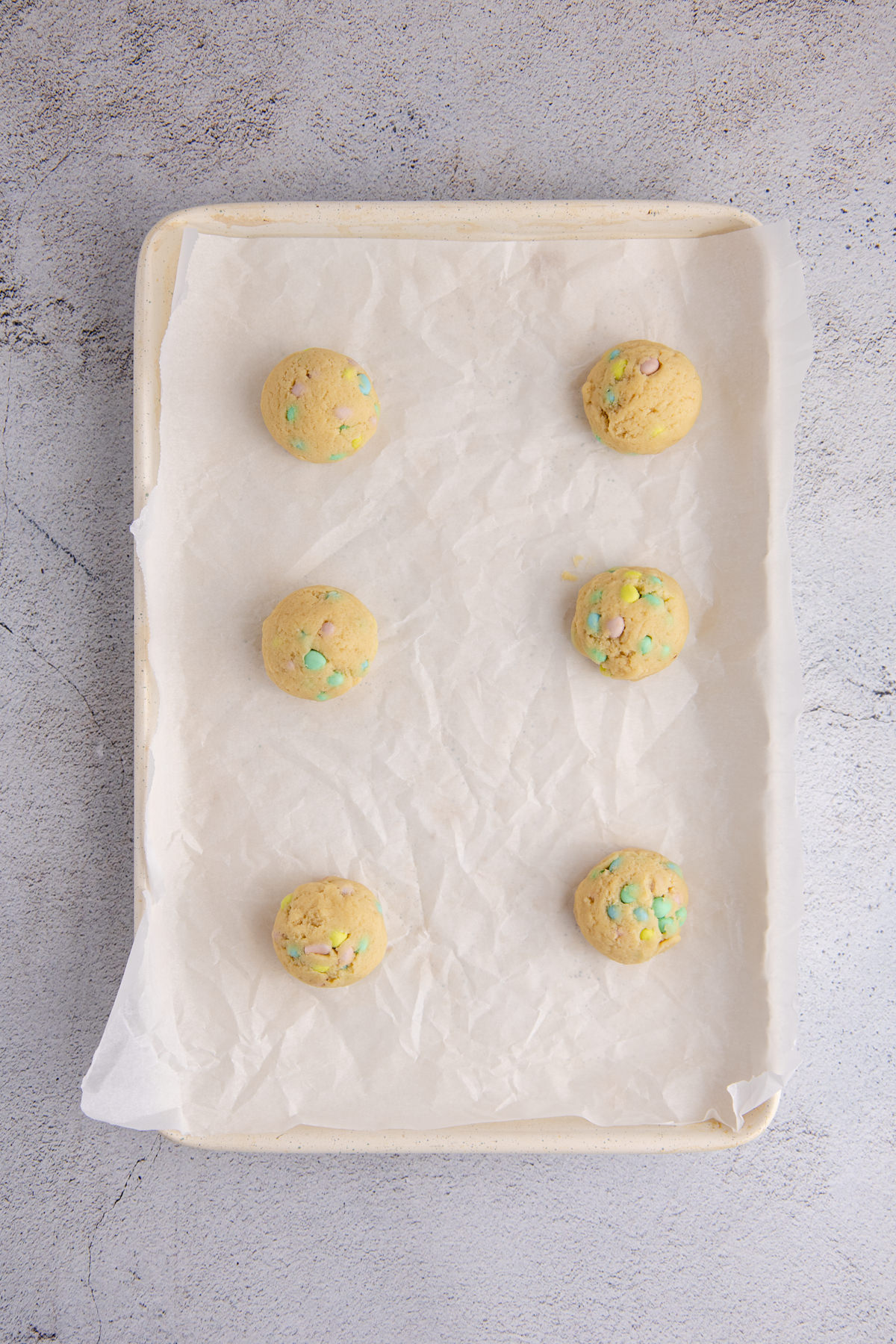 Prepared cookie dough and Cadbury mini eggs folded in then placed on a cookie sheet.
