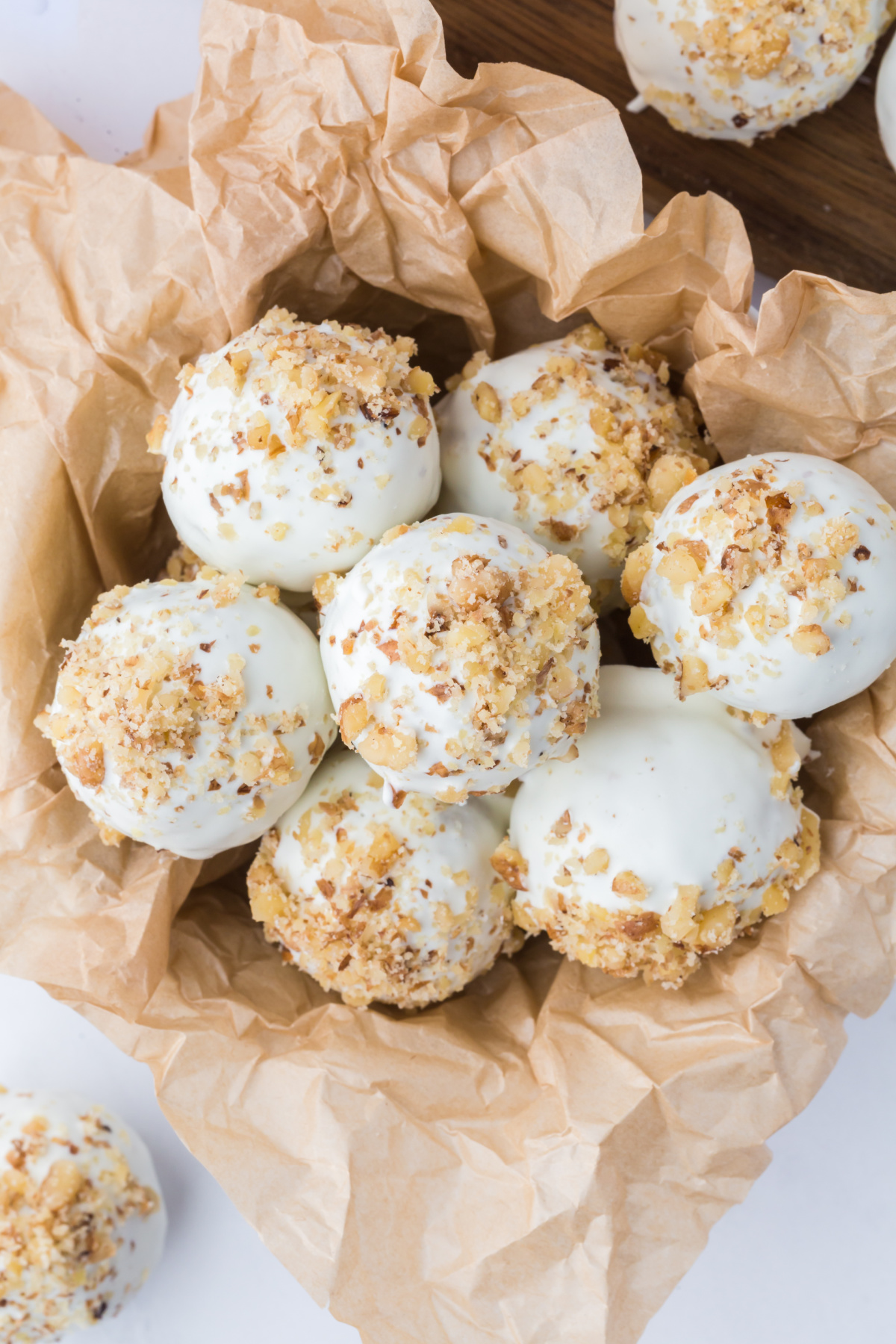 A stack of carrot cake truffles with walnuts on top.