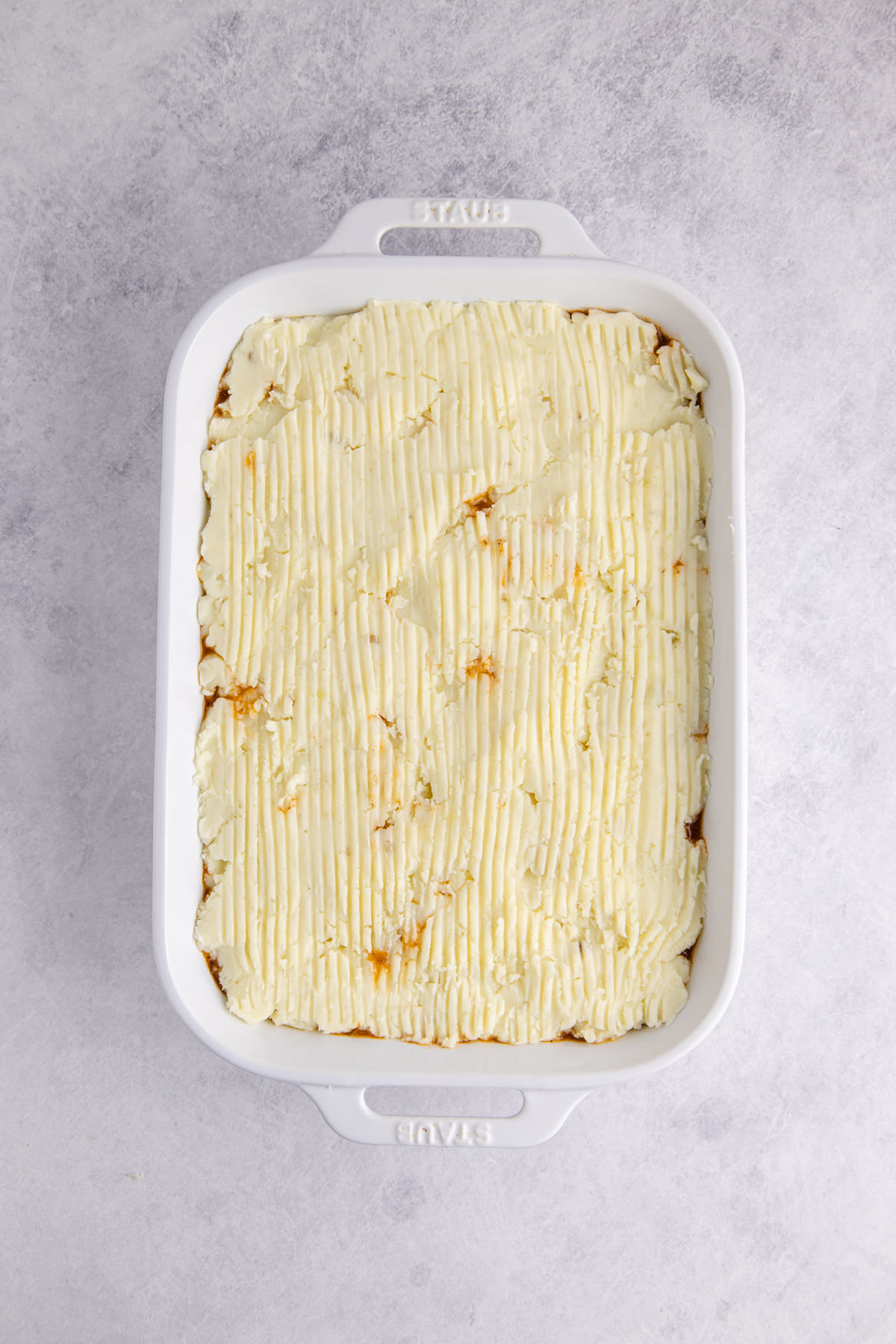 Mashed potatoes layered on top of the ground beef and veggies.