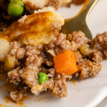 A forkbite on a plate of cottage pie.