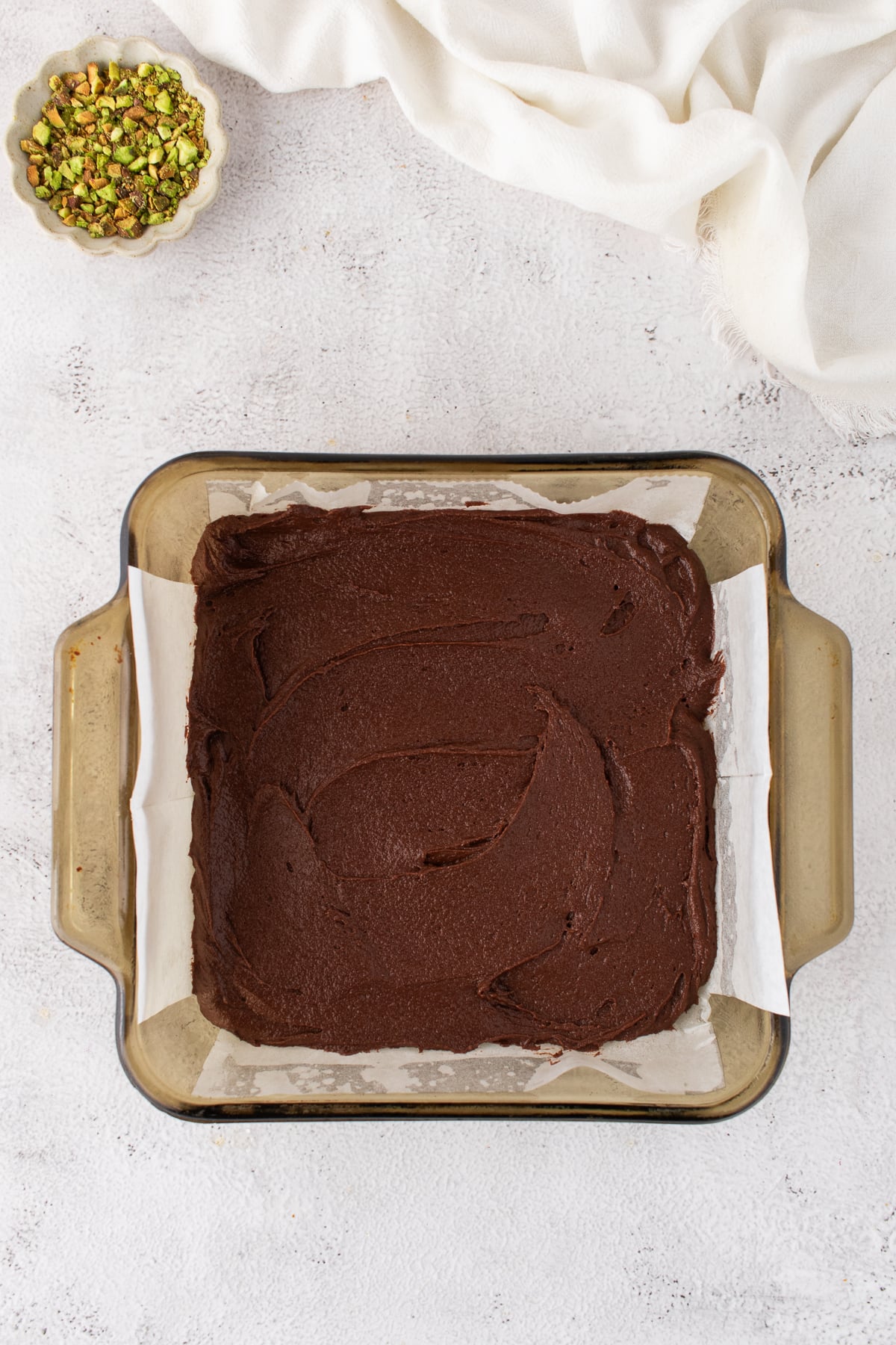 Brownie batter put into a prepared baking dish.