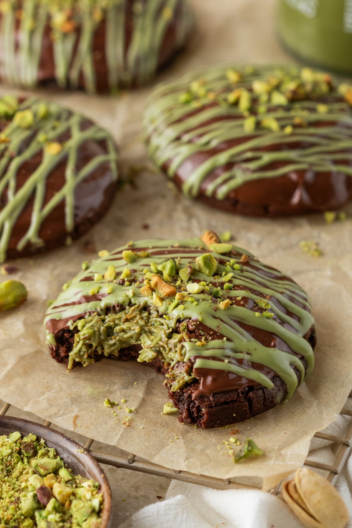 A bitten Dubai chocolate cookie on parchment paper.