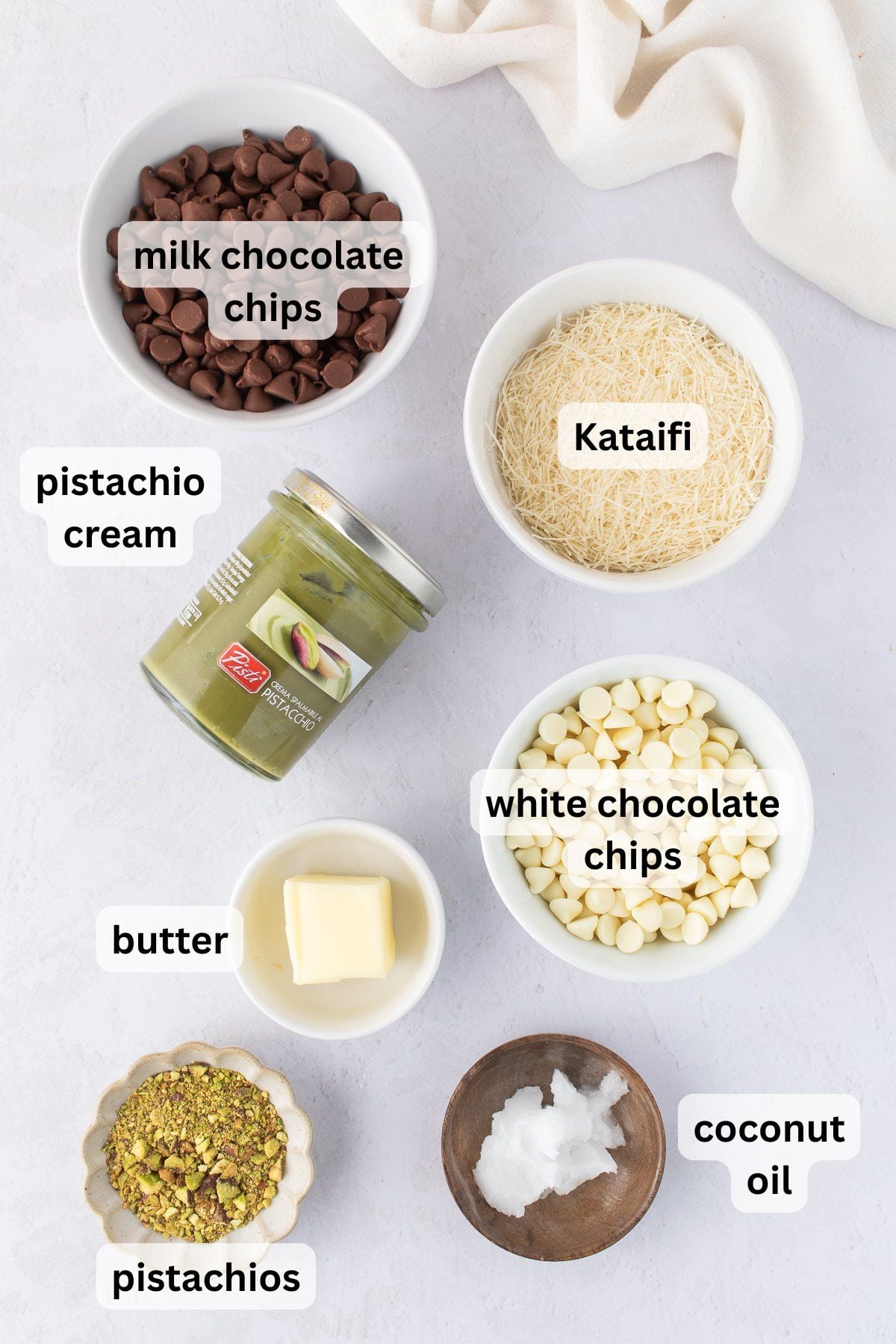 All of the ingredients needed to make Dubai chocolate bark on a table in bowls.