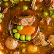Dutch oven Irish stew scooped up with a ladle.