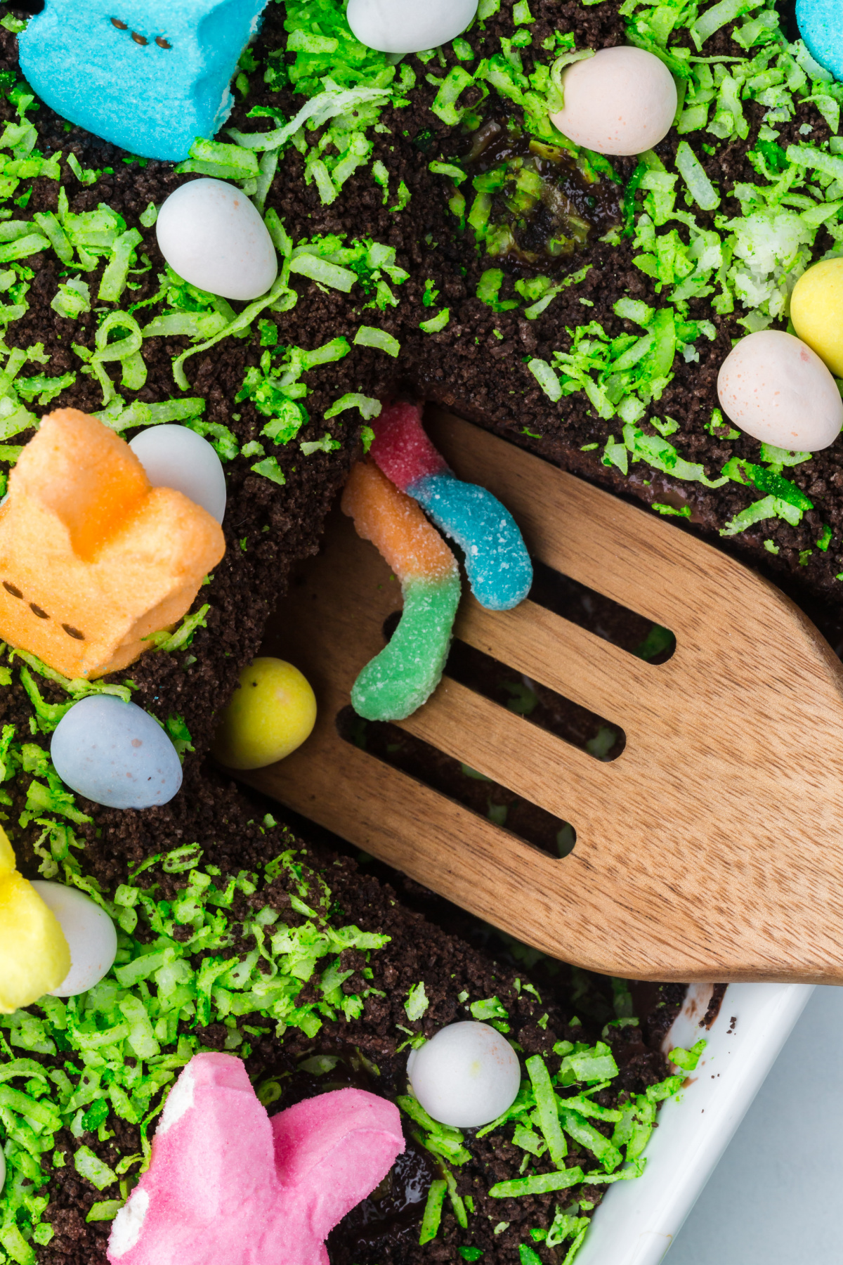 A wooden spoon scooping some Easter dirt cake up.