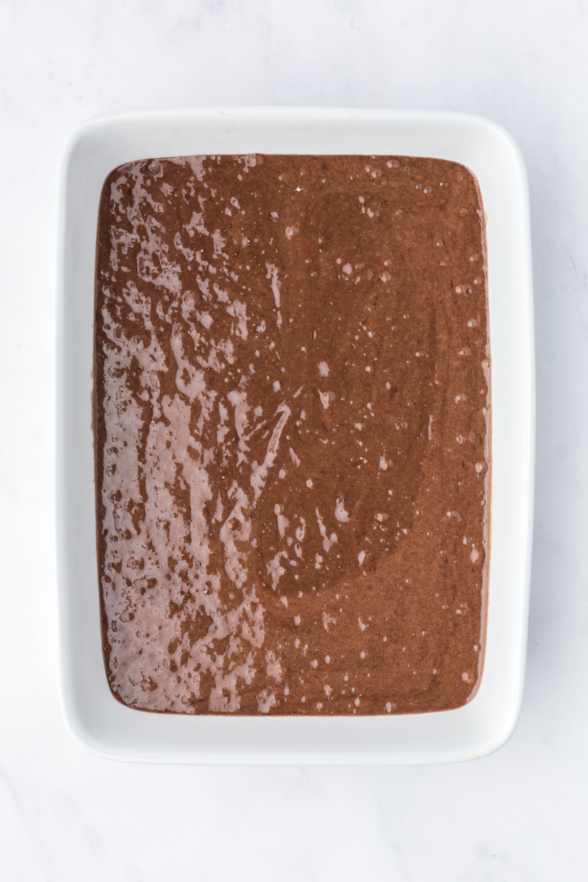 Chocolate cake batter in a baking pan.