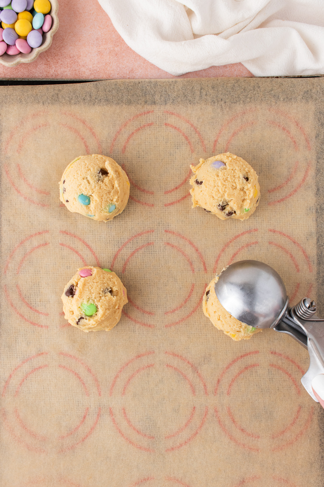 Cookie dough scooped onto a prepared sheet pan.