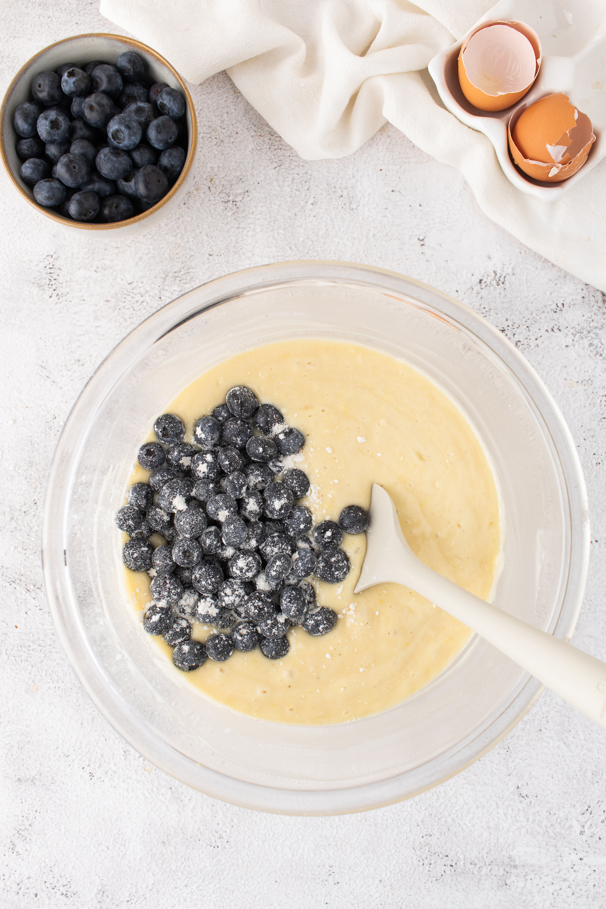 The prepared batter in a bowl with blueberries added.