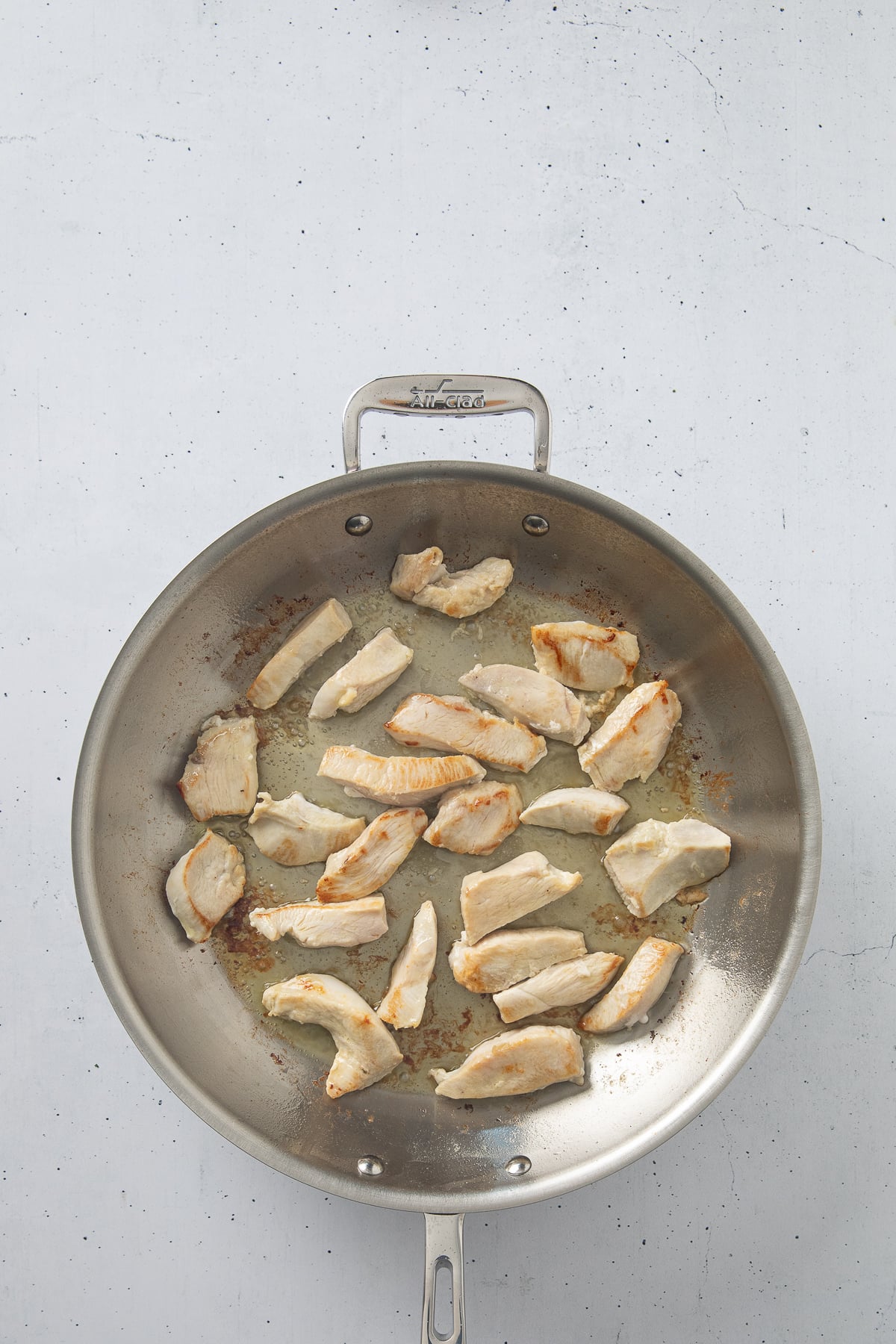 Chicken cooking in a skillet.