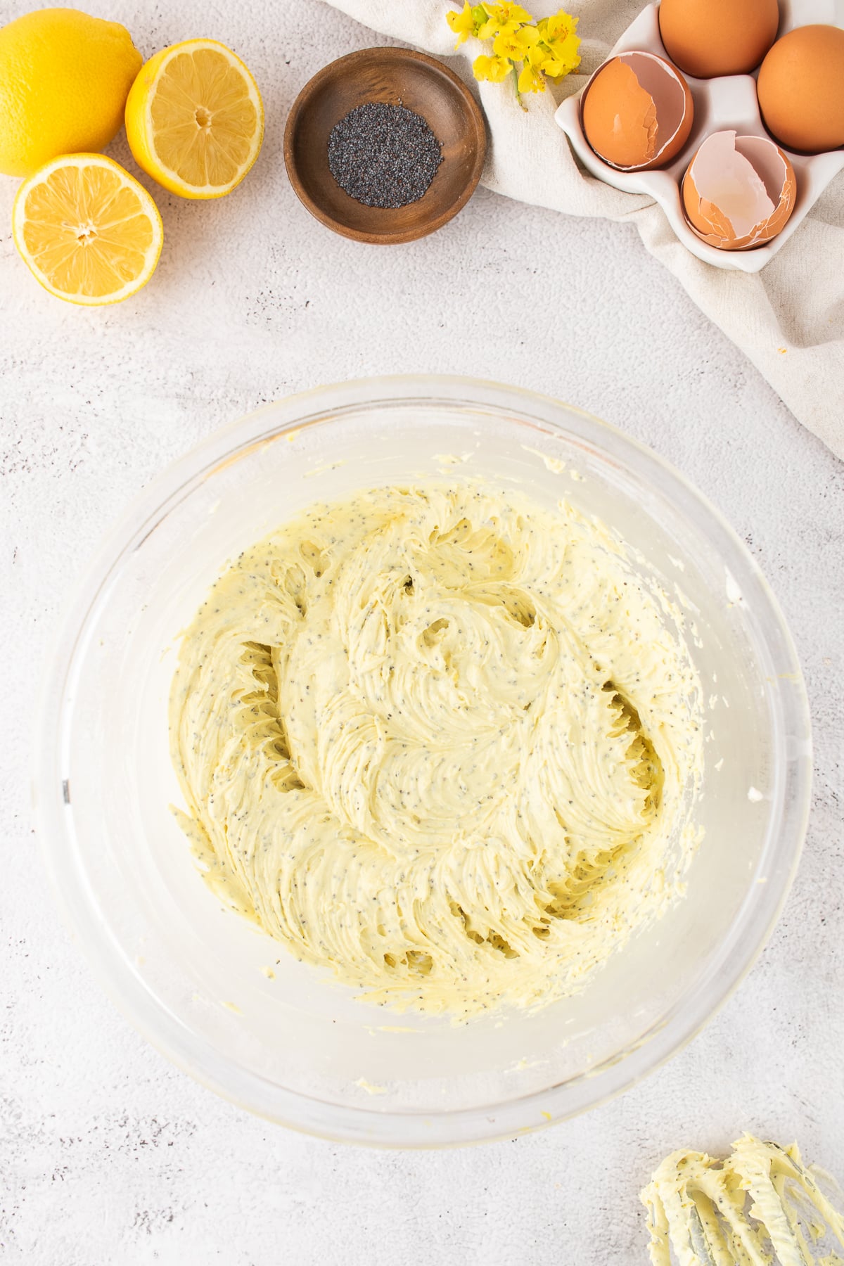 Dry and wet ingredients for lemon cupcakes combined in a bowl.