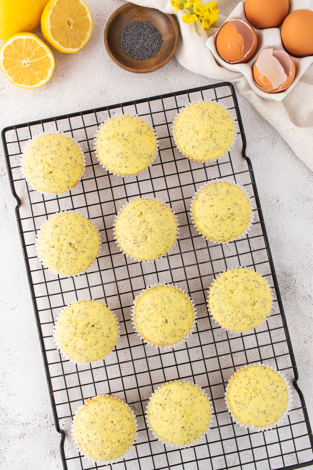 Lemon cupcakes cooling on a rack.