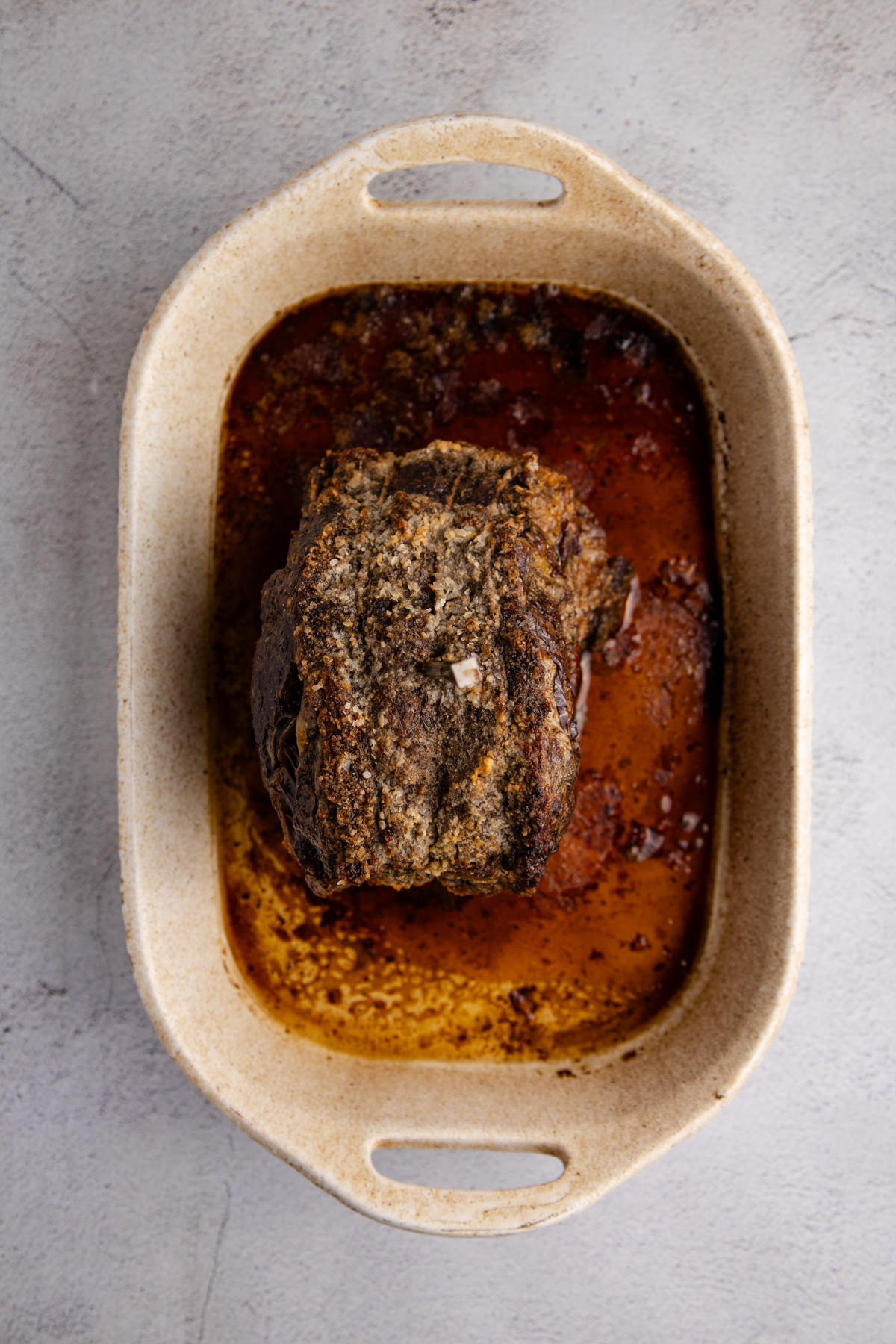 A poor man's prime rub cooked and cooling in a pan.