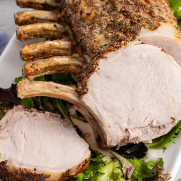 Pork prime rib being sliced while in pan