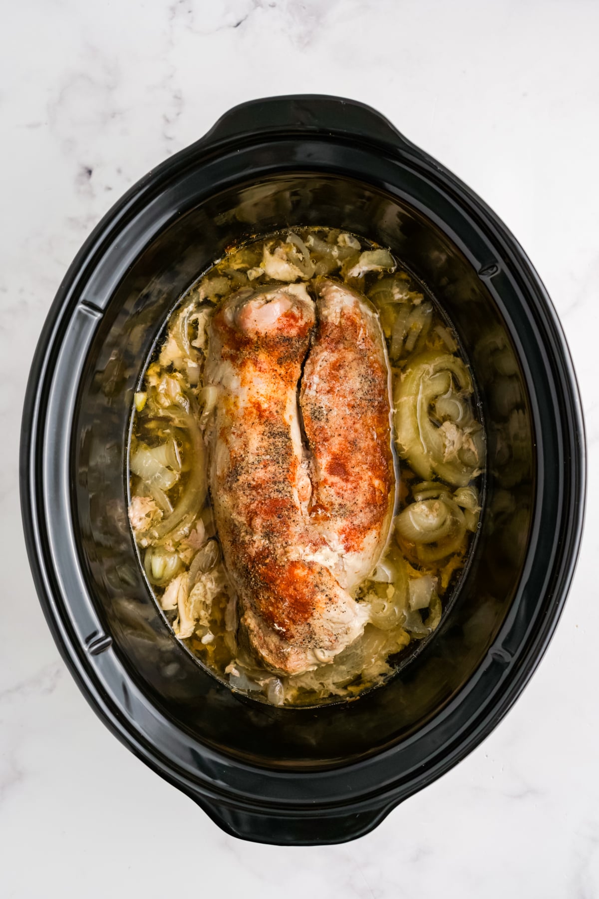 Pork tenderloin cooking in a crock pot.